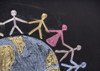 Chalk people holding hands and standing on globe